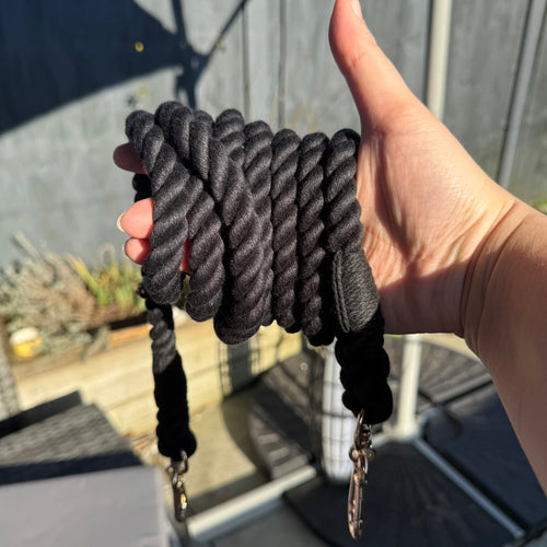Black 7ft multi-use rope lead wrapped around a hand with two clips