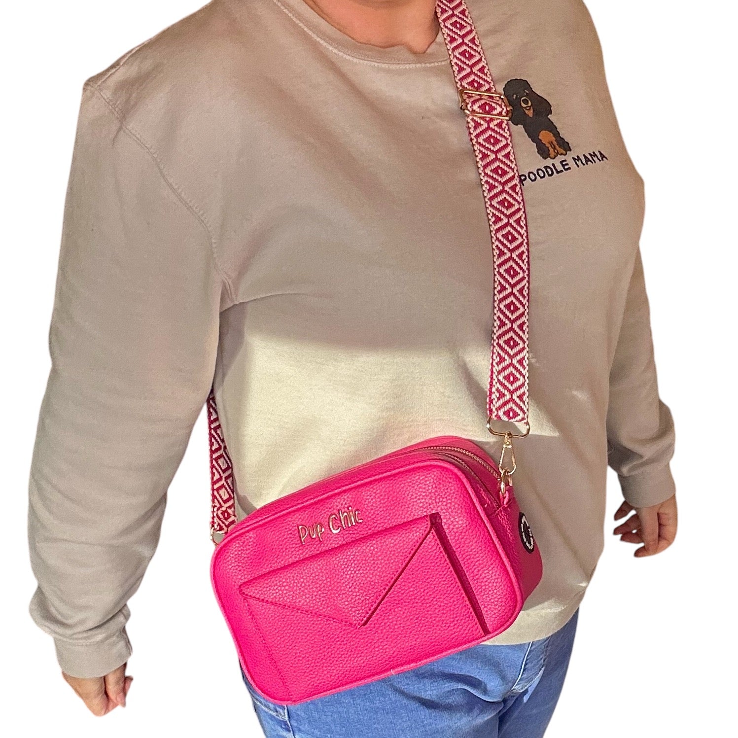Person wearing a beige sweatshirt with 'Poodle Mama' text and a pink crossbody bag.
